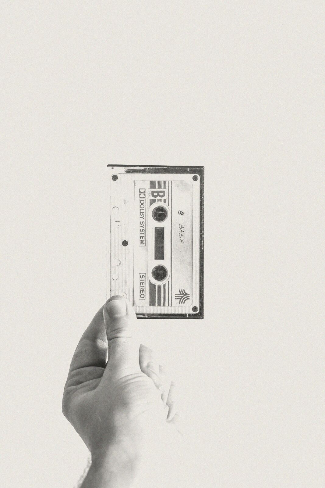 A hand holding up a cassette tape